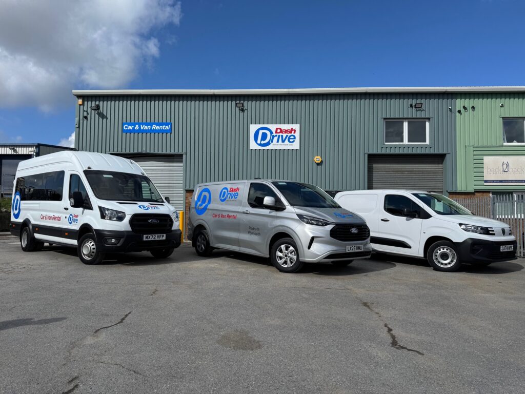 Dash Drive's new Plymouth depot featuring branded rental vans parked in front of the building with Dash Drive signage."